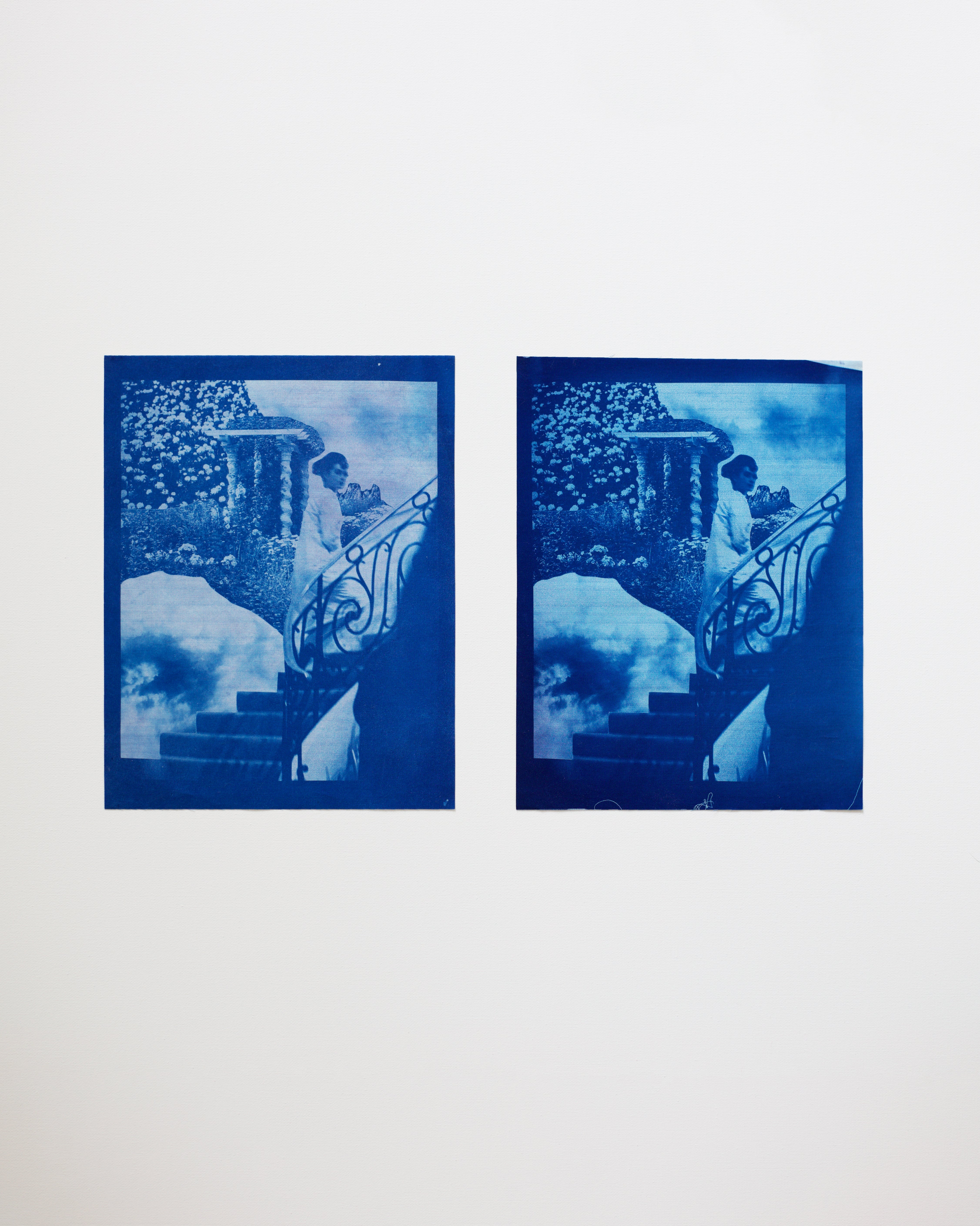Two blue-toned cyanotype prints of a person on steps against a white background