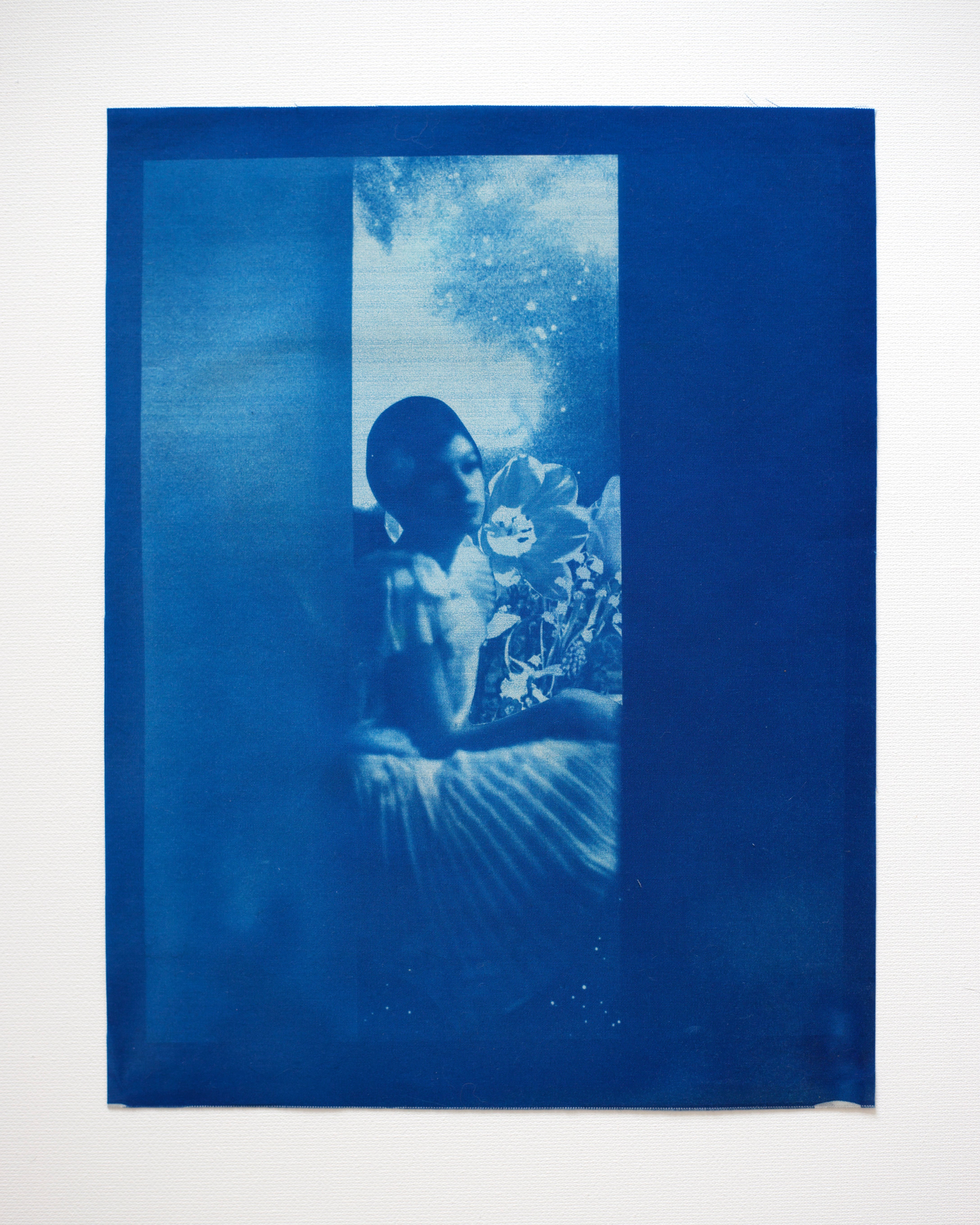 Blue-toned cyanotype artwork of a woman with flowers, framed by blue borders.